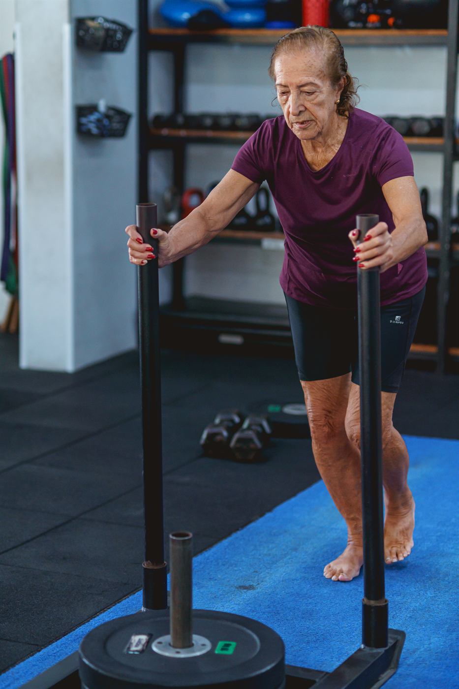 Aluna idosa treinando com sled push